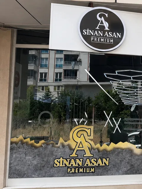 Dükkânın cephesi: tabelada yuvarlak SA amblemi, vitrinde altın SA grafiği